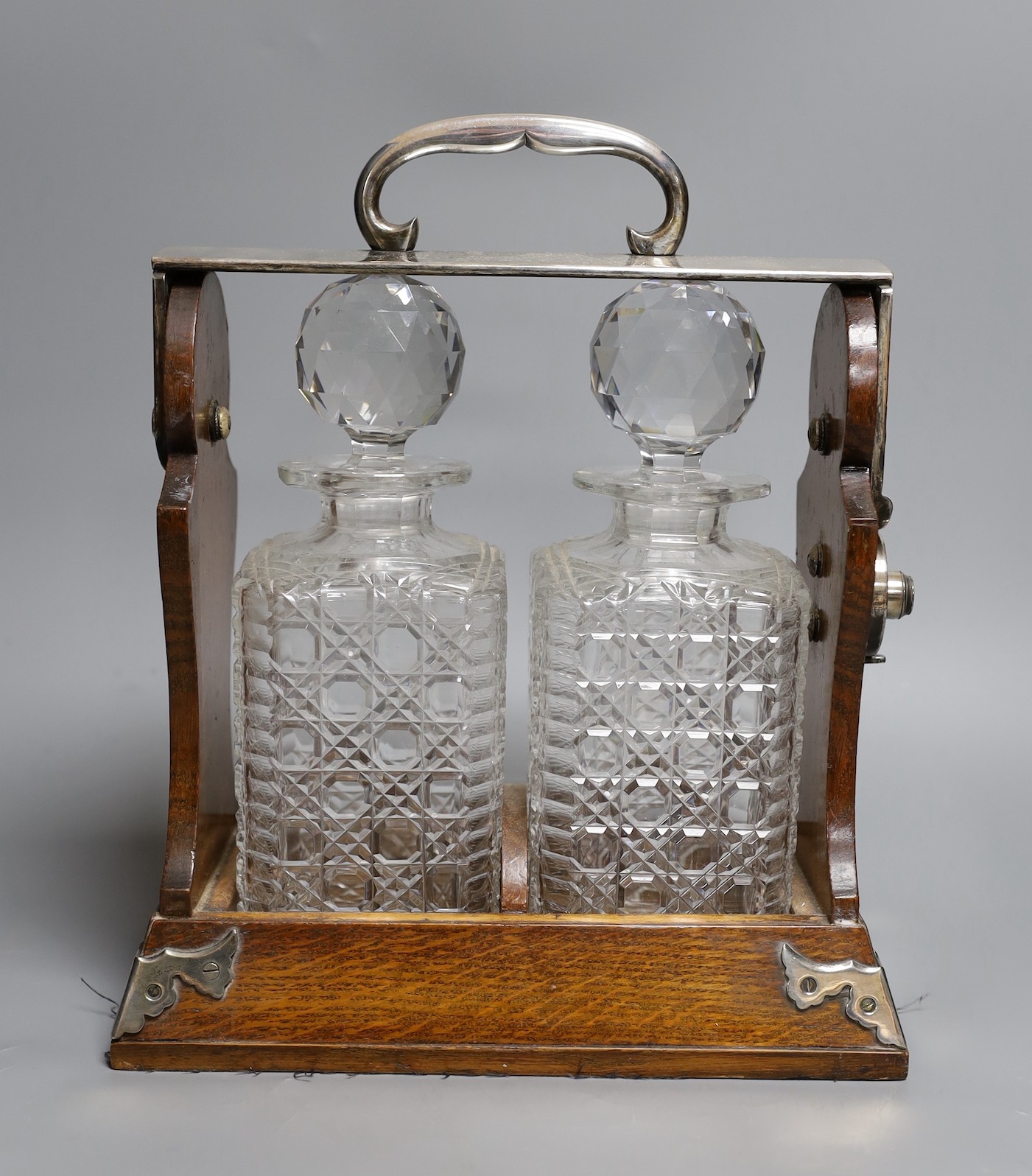 A Betjemann’s patent twin bottle oak and plated tantulus- no key, 32 cms high